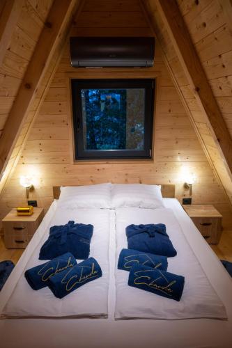 a bedroom with a white bed with blue pillows on it at Charda Guesthouse in Laktaši
