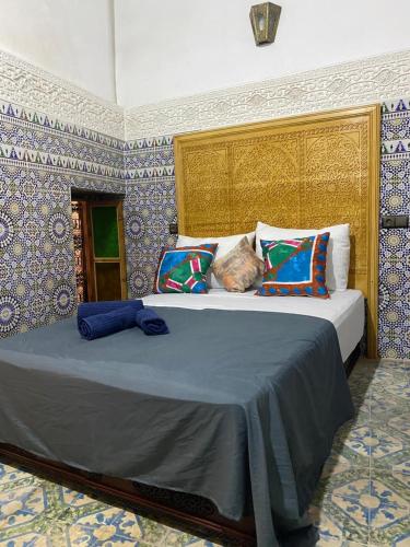 a bedroom with a large bed with colorful pillows at dar ben issa in Fez