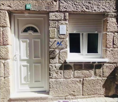 a stone building with a door and a window at Casa da Tia Binda - refúgio no centro histórico in Monção