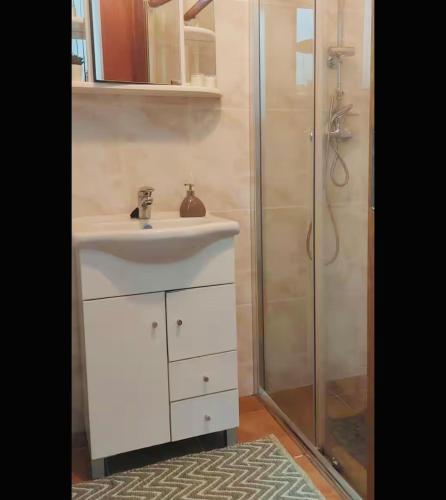 a bathroom with a white sink and a shower at Casa da Tia Binda - refúgio no centro histórico in Monção