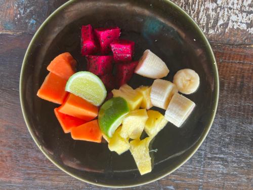 LabuhanpohにあるLombok Villas, Villa Rembulanの木のテーブルの上に刻んだ野菜の入ったボウル