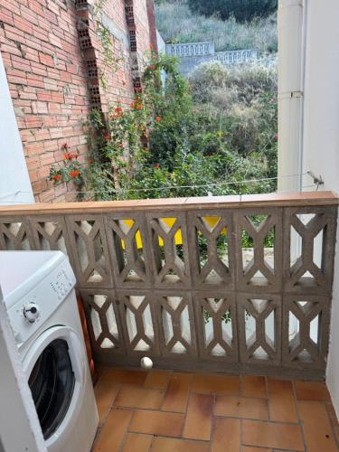 a washing machine in front of a balcony with a window at La Cantonada in Port de la Selva