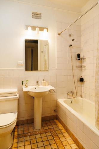 a bathroom with a sink and a toilet and a tub at Historic Loft Overlooking Plaza de Armas in Santiago