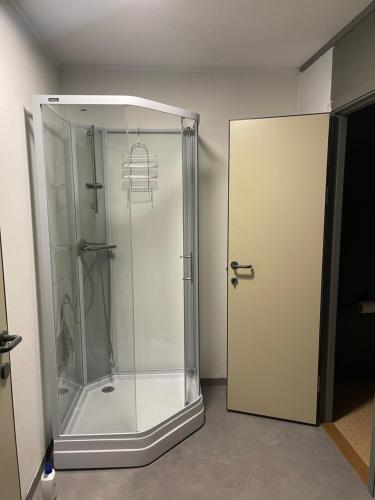 a shower stall with a glass door in a room at Ankenes Romutleie AS in Narvik