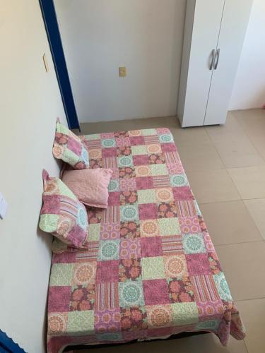 a bed with a quilt and pillows on it at pousada Requenguela in Icapuí