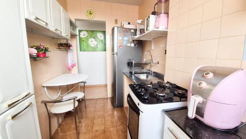 Una pequeña cocina con estufa y refrigerador. en Apartamento Aconchegante, en Belém