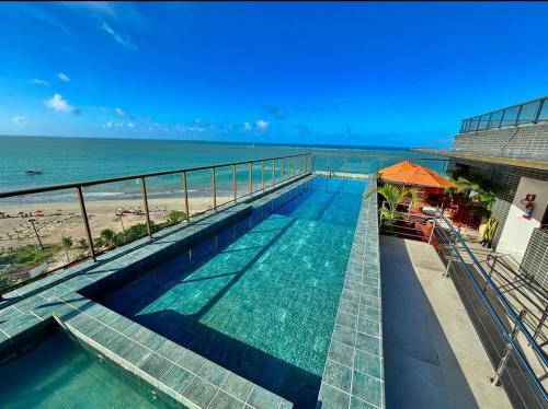a swimming pool with a view of the beach at Flat Vista-Mar in Cabedelo