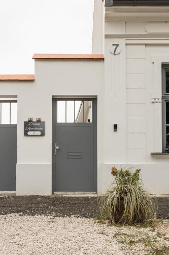 a white house with a gray door at Dream Apartman in Levél