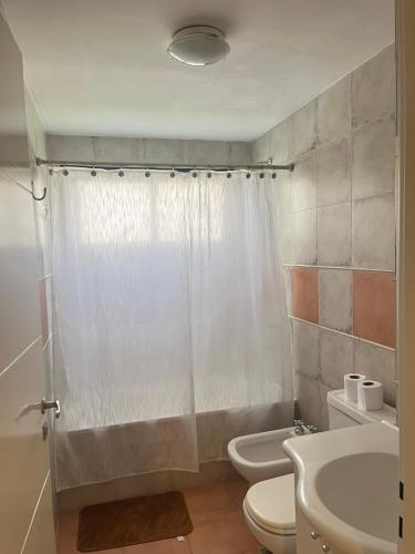 a bathroom with a white shower curtain and a toilet at Buena Vista YB in Yerba Buena