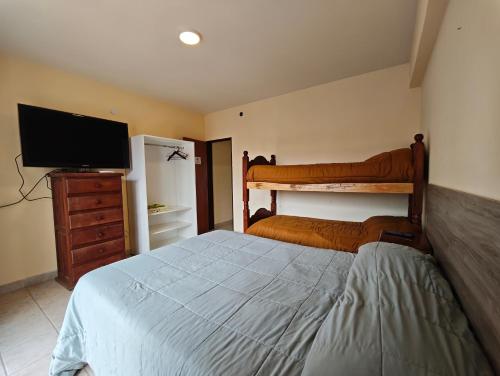 a bedroom with a bed and a flat screen tv at Keóken - Frente al Hiper Tehuelche in Caleta Olivia