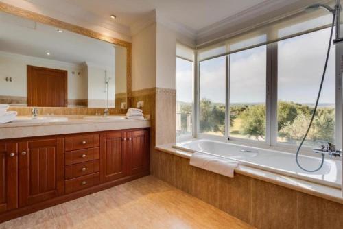 アルコス・デ・ラ・フロンテーラにあるCasa Los Olivosの浴槽と洗面台と窓のあるバスルーム