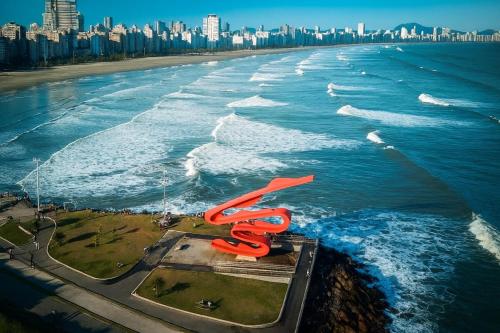 an aerial view of the beach with a red sculpture at Apartamento Frente ao Mar no Embaré Moderno Completo com Vaga in Santos
