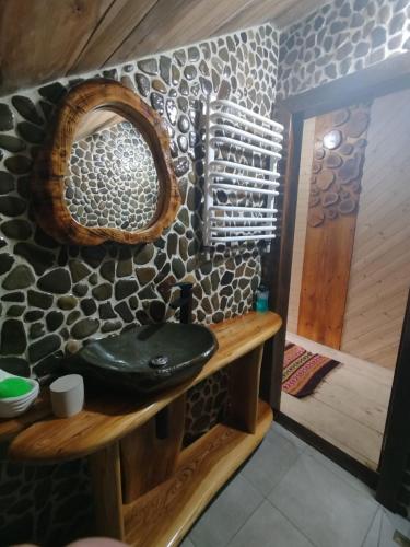 a bathroom with a sink and a stone wall at Корінь in Krasnoilov