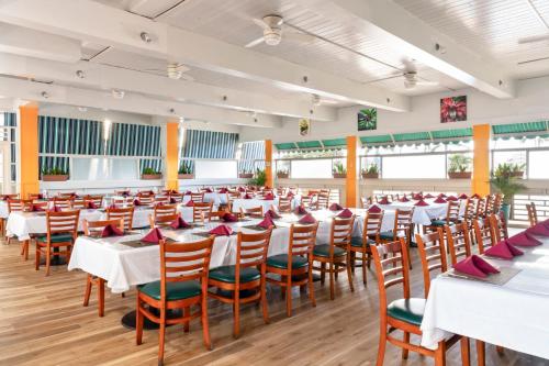 カフルイにあるマウイ ビーチ ホテルの白いテーブルと椅子のあるダイニングルーム