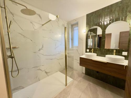 a bathroom with two sinks and a shower at T4 moderne parking Théodore Bac - DABNB in Limoges