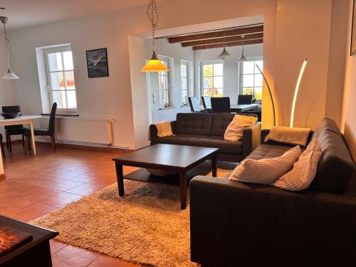 a living room with two couches and a table at Kranichhaus Boddenblick in Saal