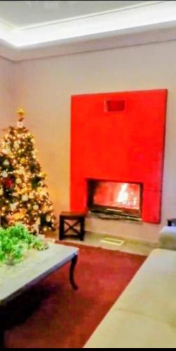 a living room with a christmas tree and a fireplace at Fella Chalkida in Chalkida