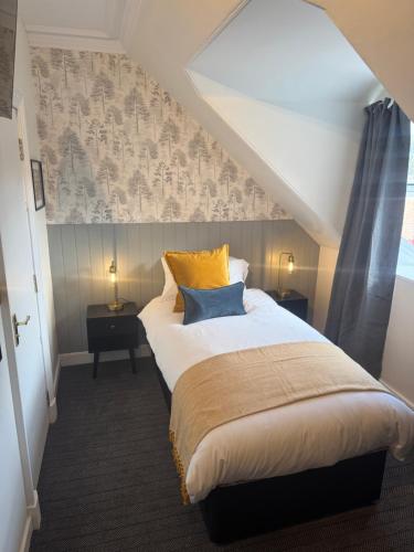 a bedroom with a large bed with yellow and blue pillows at The Law in North Berwick