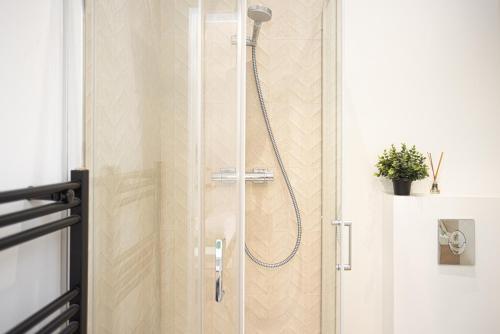 a shower with a glass door in a bathroom at Studio GOOD VIBES - Wifi - Cosy - Hyper-centre in Orléans