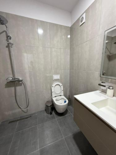 a bathroom with a toilet and a sink and a shower at Modern 2BR Near City Ring & Main Road Access in Tirana