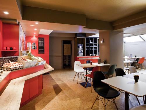 a restaurant with tables and chairs and red walls at ibis Paris Gare De L'Est TGV in Paris