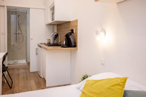 una stanza con un letto e una cucina con un lavandino di Mathou a Orléans