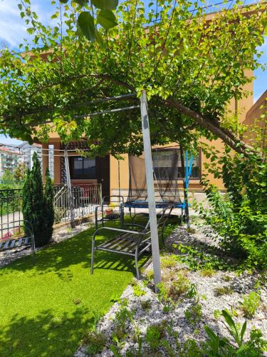a bench sitting under a tree in a yard at Oporto Glamour Suite House in Vila Nova de Gaia