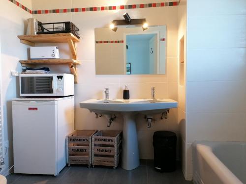 Un baño con lavabo y microondas. en Chambre indépendante avec WC et salle de bain, en Urrugne