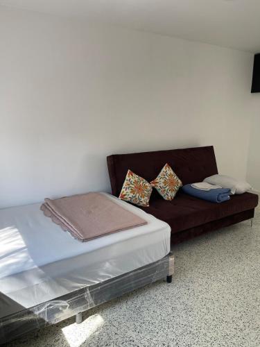 a brown couch with pillows on it in a room at Consulado Americano Santa Catarina a 3 min in Monterrey