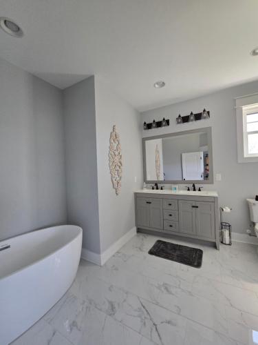 a white bathroom with a tub and a mirror at Luxurious Eastern Shore Getaway in Milton