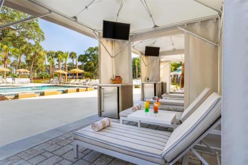 an outdoor patio with lounge chairs and a pool at Sonesta Resort Hilton Head Island in Hilton Head Island