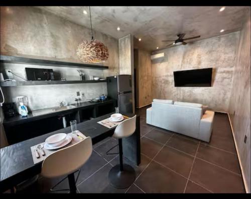 eine Küche mit einem Tisch und einer Couch in einem Zimmer in der Unterkunft Coco Live Suites in Playa del Carmen