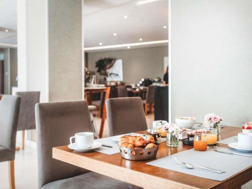 a wooden table with a bowl of food on it at Le Diwan Hotel Rabat - MGallery Collection in Rabat