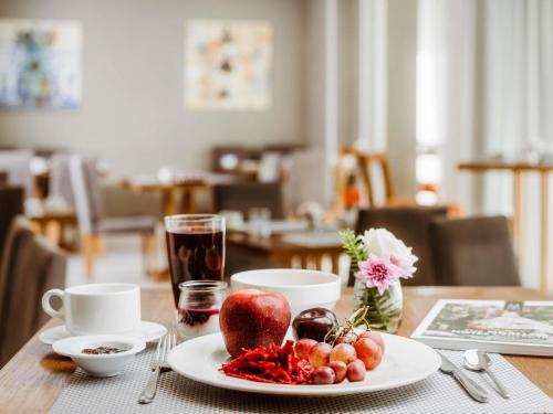 a table with a plate of fruit on a table at Le Diwan Hotel Rabat - MGallery Collection in Rabat