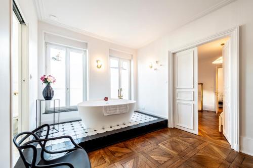 a bathroom with a tub on a tiled floor at Gîte Vosges en Ville luxueux appartement Duplex avec sauna espace bien être au centre d'Epinal in Épinal