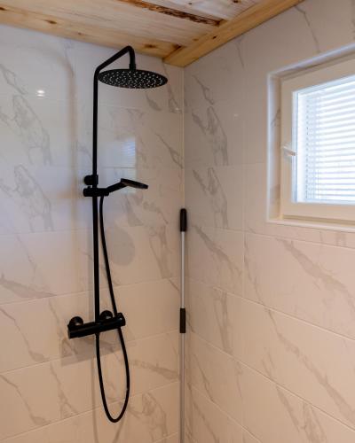 a shower with a black shower head in a bathroom at Töyräniemi in Pälkäne