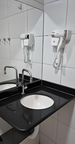 a bathroom with a sink and two mirrors at Apartamento Brisa do Mar in Natal