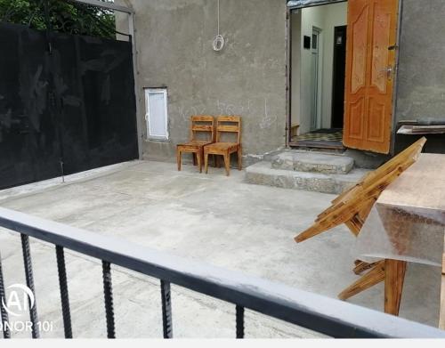 un patio con due sedie di legno e uno specchio di Bağ evi a Quba