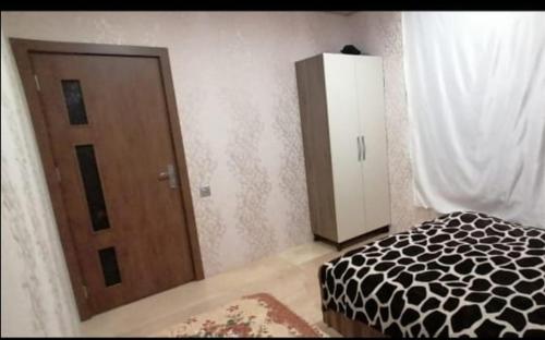 una stanza con un letto, una porta e un armadio di Bağ evi a Quba