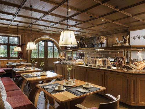 a restaurant with tables and chairs and a counter at Mercure Hotel Garmisch Partenkirchen in Garmisch-Partenkirchen
