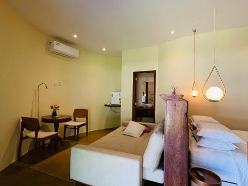 um quarto com uma cama, uma mesa e cadeiras em POUSADA PONTA DA ASA em Coruripe