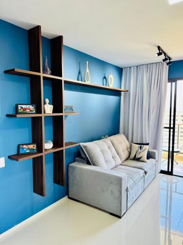 a living room with a couch against a blue wall at apartamento com vista para o mar in Aracaju