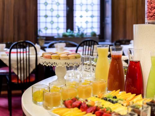 Una mesa con una bandeja de fruta y jugo. en Carlton Hotel Lyon - MGallery Collection, en Lyon