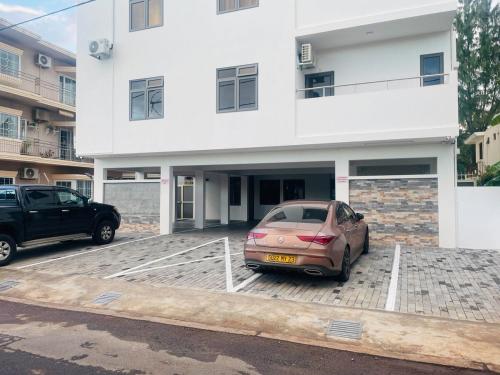 a car parked in a parking lot in front of a building at Sunset Views 3-Bedroom Apt, 1min Walk to Beach - NYHA1 in Flic-en-Flac