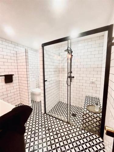 a bathroom with a shower with black and white tile at Casa Nidos in Santiago
