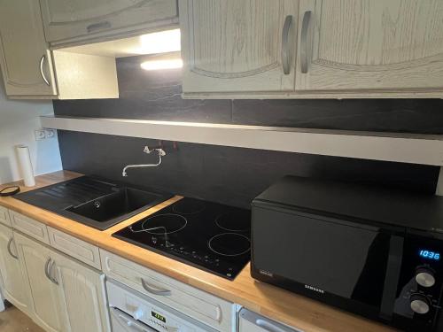 a kitchen with a stove and a microwave at Studio cosy à Métabief in Métabief