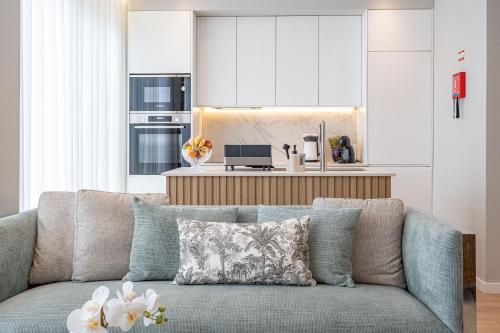 a living room with a couch and a kitchen at Casa Graminho in Ponta do Sol