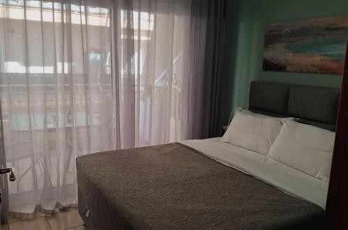 a bedroom with a bed and a window with curtains at M.O.M.’s in Alexandroupoli