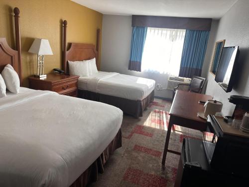 a hotel room with two beds and a desk at Americas Best Value Inn Hayward in Hayward