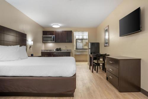 a hotel room with a bed and a kitchen at SureStay Studio by Best Western Gonzales in Gonzales